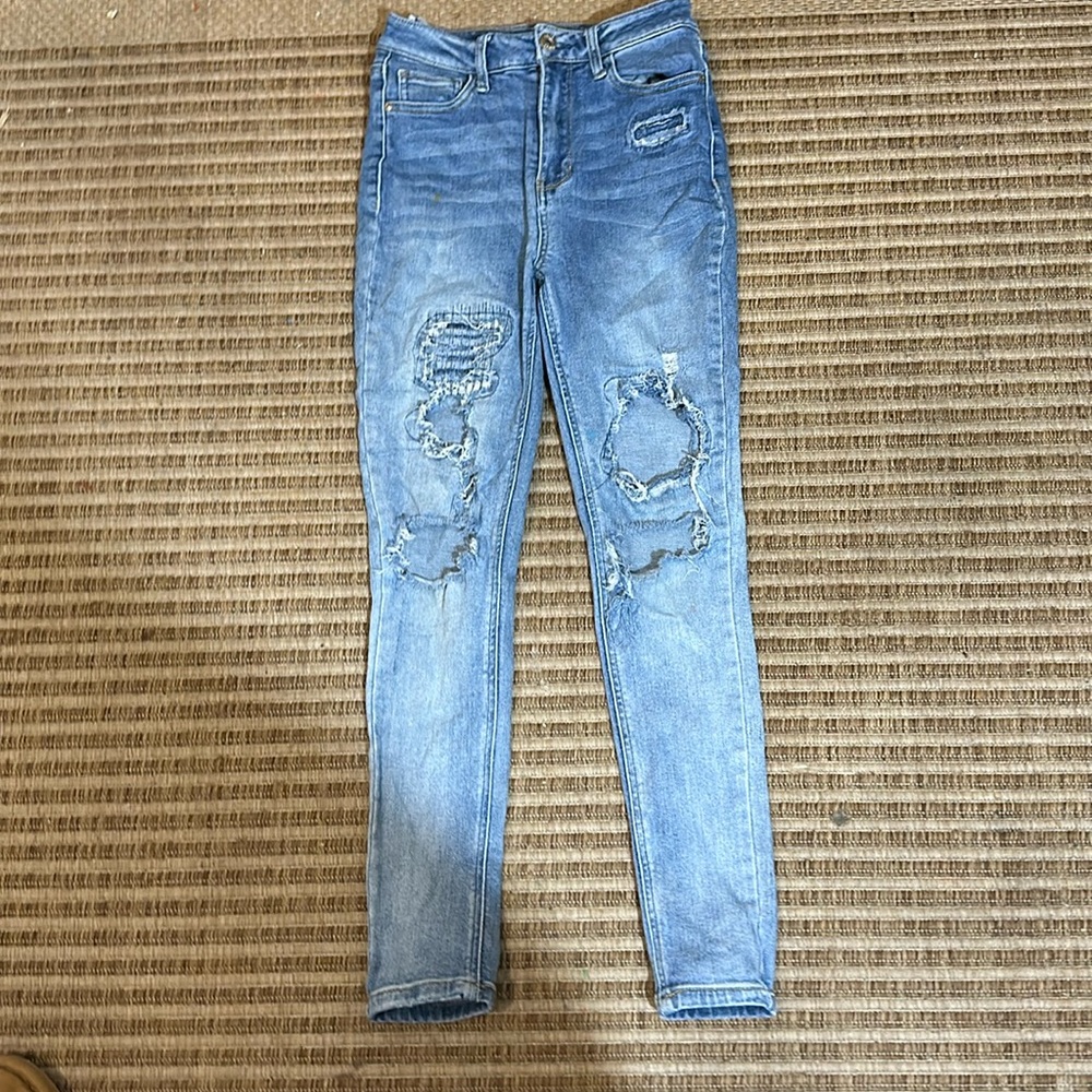 Kids size one, skinny ripped blue jeans. With a washed color.